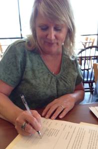 Me signing my first publication contract with Oghma Creative Media. Photo by Casey Cowen, Oghma president